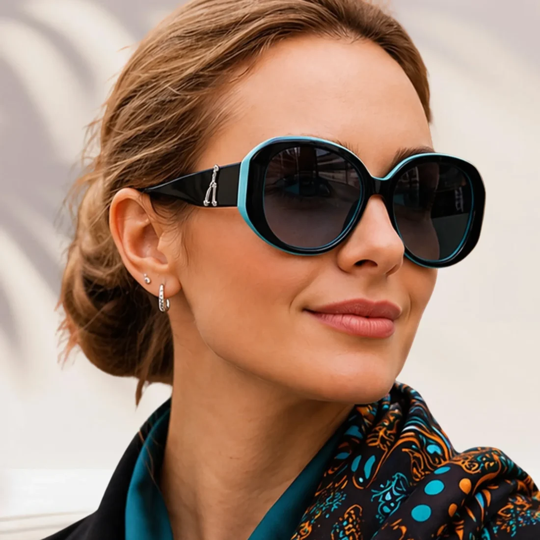 Woman wearing black and turquoise polarized sunglasses with oversized round frames and dark tinted lenses