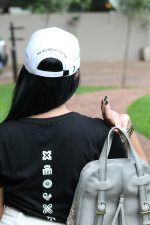 Model wearing black Zuri Nzuri cotton t-shirt with Adinkra symbol print on back
