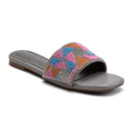 Close-up of beaded embellishments on sunset pink slip-on sandals