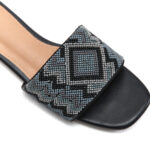 Close-up of zig-zag beadwork and diamond motif on jet black beaded sandal strap
