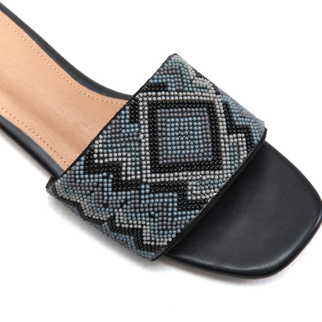 Close-up of zig-zag beadwork and diamond motif on jet black beaded sandal strap