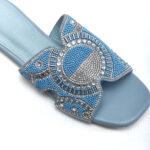 Close-up of blue and clear crystal beadwork on slate blue sandal strap