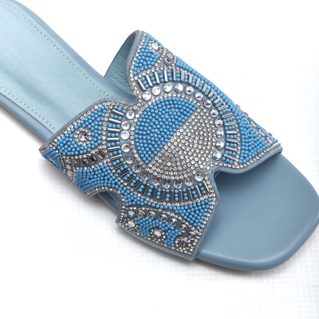 Close-up of blue and clear crystal beadwork on slate blue sandal strap