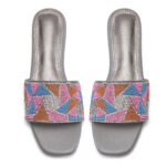 Close-up of beaded embellishments on sunset pink slip-on sandals