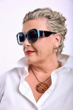Woman wearing black and turquoise polarized sunglasses with oversized round frames and dark tinted lenses
